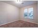 This cozy bedroom features a neutral carpet, light-colored walls, and a window at 982 Ashton Park Dr, Lawrenceville, GA 30045