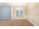 A bright dining room features a modern chandelier and a large window with white trim at 982 Ashton Park Dr, Lawrenceville, GA 30045