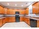 Spacious kitchen with wooden cabinets, granite countertops, and modern black appliances at 982 Ashton Park Dr, Lawrenceville, GA 30045