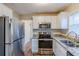 Well-equipped kitchen with stainless steel refrigerator, microwave, and granite countertops at 2080 Dellwood Pl, Decatur, GA 30032