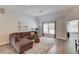 Cozy living room featuring a comfortable sofa, accent rug, and plenty of natural light from a large window at 608 Sweetfern Ln, Sugar Hill, GA 30518