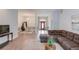 Bright living room showcasing an open-concept design, a brown sectional sofa, and wood-look flooring at 608 Sweetfern Ln, Sugar Hill, GA 30518