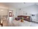 Open-concept living room featuring a brown sectional sofa, modern decor, and wood-look flooring at 608 Sweetfern Ln, Sugar Hill, GA 30518