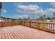 A wood deck with a view of trees and a partly cloudy sky at 7890 Bristol Valley Dr, Cumming, GA 30028