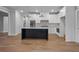 Open kitchen layout with a dark island, white cabinets, and stainless steel appliances at 2021 Shallowford Rd, Marietta, GA 30066