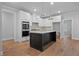 Stylish kitchen featuring a black island, white cabinetry, stainless steel appliances, and modern lighting at 2021 Shallowford Rd, Marietta, GA 30066