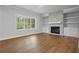 Bright living room with hardwood floors, a fireplace, and built-in shelving at 2021 Shallowford Rd, Marietta, GA 30066