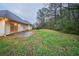 Large, grassy backyard with ample space and an exterior view of the rear of the home at 5087 Donnell Way, Decatur, GA 30035