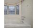 Bathroom featuring a white bathtub with tile surround and a window for natural light at 5087 Donnell Way, Decatur, GA 30035