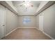 Neutral primary bedroom featuring tile floors, a tray ceiling with a ceiling fan and two closets at 5087 Donnell Way, Decatur, GA 30035