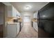Modern kitchen with white cabinets, tile floors, and black appliances, seamlessly connecting to the dining area at 5087 Donnell Way, Decatur, GA 30035