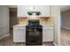 Functional kitchen showcasing black appliances, tile backsplash, and bright white cabinetry at 5087 Donnell Way, Decatur, GA 30035