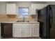 Efficient kitchen space equipped with white cabinetry, tile floors, neutral countertops, and black appliances at 5087 Donnell Way, Decatur, GA 30035