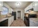Well-lit kitchen featuring modern appliances, white cabinetry, tile backsplash, and tile flooring at 5087 Donnell Way, Decatur, GA 30035