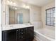 Bathroom with double sinks, a soaking tub, and dark cabinets at 2293 Chancery Mill Ln, Buford, GA 30519