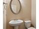 Powder room features pedestal sink, large oval mirror and modern fixtures at 2293 Chancery Mill Ln, Buford, GA 30519