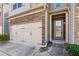 Exterior view of a two-story townhome with stone accents around the garage at 2293 Chancery Mill Ln, Buford, GA 30519