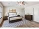 Bright bedroom features a ceiling fan, a large rug, and neutral decor at 2293 Chancery Mill Ln, Buford, GA 30519