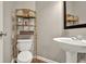 Compact half bathroom with a pedestal sink, bamboo shelf, and wood-look flooring at 236 Balaban Cir, Woodstock, GA 30188