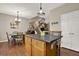 Kitchen island with cabinets in open concept kitchen with hardwood floors and dining table at 236 Balaban Cir, Woodstock, GA 30188