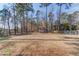 View of the large, flat backyard with mature trees and small storage shed at 4808 Sunview Ct, Suwanee, GA 30024