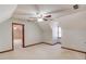 Large carpeted bedroom with attic ceiling, ceiling fan, window, and doorway to another room at 4808 Sunview Ct, Suwanee, GA 30024