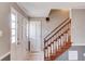 Bright entryway with tiled flooring, staircase with wood railing, and a coat closet near the front door at 4808 Sunview Ct, Suwanee, GA 30024