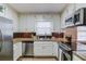 Well-appointed kitchen with stainless appliances, granite counters, white cabinets, and adjacent dining area at 4808 Sunview Ct, Suwanee, GA 30024