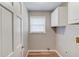 Functional laundry room with wood-look floors, storage cabinets, and window for natural light at 4808 Sunview Ct, Suwanee, GA 30024