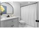 Clean bathroom featuring white fixtures, vanity storage and modern faucet with decorative mirror at 770 Waters Sw Dr, Atlanta, GA 30310