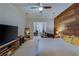 Bright main bedroom features wood accent wall, ceiling fan, neutral carpet and a large television at 832 Chalet Hls, Mcdonough, GA 30253