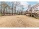 Large backyard with a wooden deck and staircase, and a treeline in the distance at 1070 Thornwood Cir, Covington, GA 30016