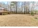 Large backyard featuring a wooden deck and staircase, and a treeline in the distance at 1070 Thornwood Cir, Covington, GA 30016