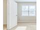 Bright bedroom featuring neutral walls, carpet, and window, and door at 1070 Thornwood Cir, Covington, GA 30016