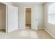 Bright bedroom with neutral walls, carpet, window, and closet with double doors at 1070 Thornwood Cir, Covington, GA 30016