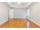 Large bedroom with tray ceiling, wood floors and an open doorway at 1070 Thornwood Cir, Covington, GA 30016