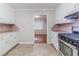 Bright kitchen with sleek appliances and white cabinets, with a view to a hardwood floor dining area at 1070 Thornwood Cir, Covington, GA 30016