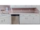 Close-up of the kitchen featuring stainless steel dishwasher and white cabinetry at 1070 Thornwood Cir, Covington, GA 30016