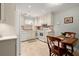 Bright kitchen with white cabinets, tile backsplash, and matching appliances, complemented by a cozy dining area at 1745 Pierce Arrow Pkwy, Tucker, GA 30084