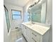 Modern bathroom with marble floors, white cabinets, and a large mirror at 6553 Meadowbrook Ln, Morrow, GA 30260