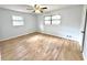 Well-lit bedroom features hardwood floors, a ceiling fan, and two windows that provide natural light at 6553 Meadowbrook Ln, Morrow, GA 30260