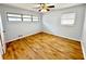 A comfortable bedroom with hardwood floors, ceiling fan, and two windows that provide natural light at 6553 Meadowbrook Ln, Morrow, GA 30260