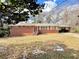 Charming single-story red brick home featuring a covered carport and a well-maintained front yard at 6553 Meadowbrook Ln, Morrow, GA 30260