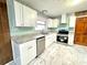 Modern kitchen featuring white cabinets, stainless steel appliances, and marble floors at 6553 Meadowbrook Ln, Morrow, GA 30260
