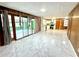 Open living space with wood paneled walls, updated flooring and leading to a bright sunroom and kitchen with stainless steel appliances at 6553 Meadowbrook Ln, Morrow, GA 30260