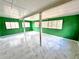 Bright sunroom with white and green walls, large windows and updated flooring at 6553 Meadowbrook Ln, Morrow, GA 30260