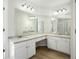 Well-lit bathroom boasts granite countertops, and sinks, and ample cabinet space at 10950 Glenhurst Pass, Duluth, GA 30097