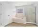 Bathroom features a soaking tub, separate glass shower, and a window letting in natural light at 10950 Glenhurst Pass, Duluth, GA 30097