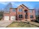 Charming two-story red brick home with a well-manicured lawn and attached two-car garage at 10950 Glenhurst Pass, Duluth, GA 30097