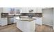 Stylish kitchen with white cabinets, granite countertops, stainless steel appliances, and kitchen island at 10950 Glenhurst Pass, Duluth, GA 30097